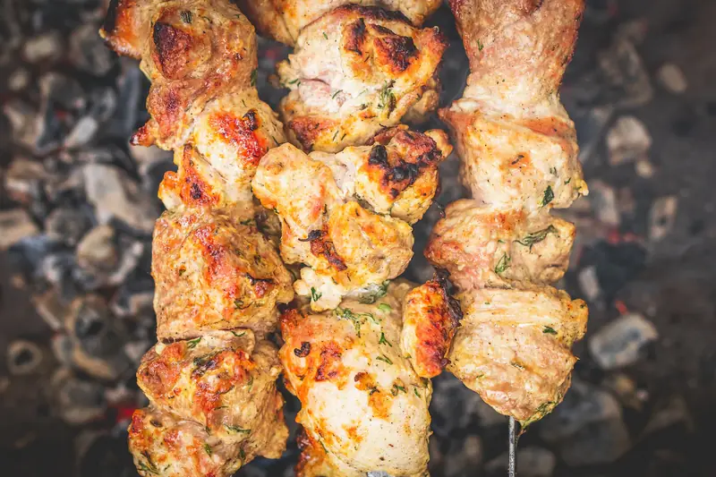Chicken souvlaki browning on the grill