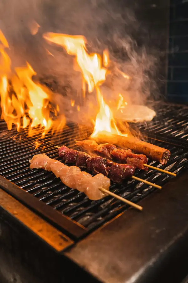 Skewers over open flames on the charcoal grill