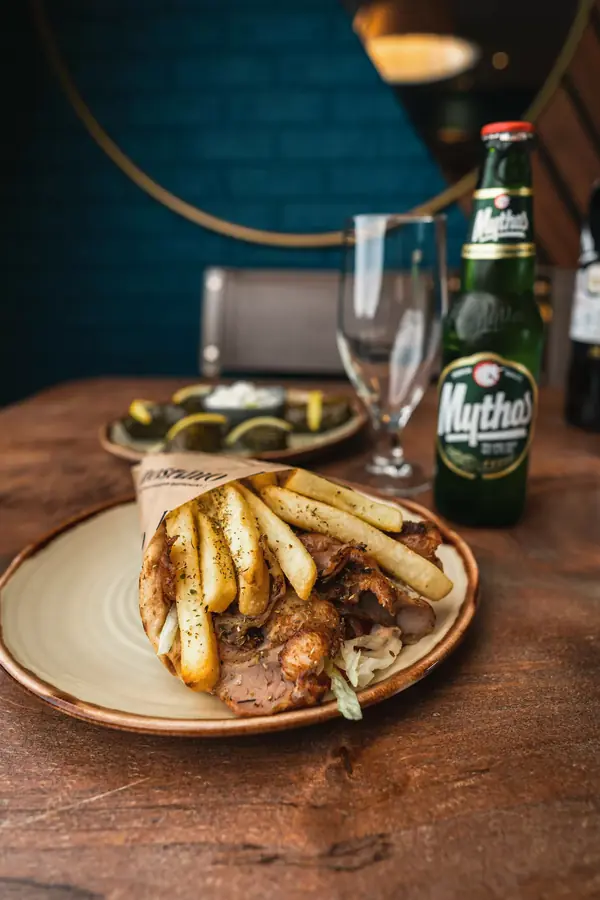 A Greek pitta wrap with a bottle of Mythos beer