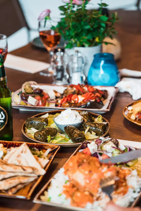 A full table of Greek dishes, herbs and wine