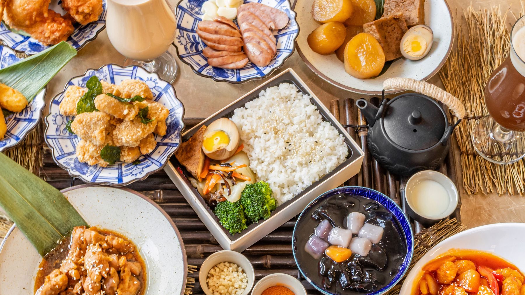 A table of S'MORE dishes: braised pork rice, fried chicken, braised egg and tofu, milk tea and taro dessert