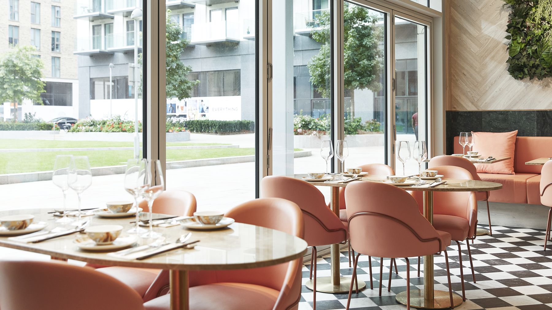 The dining room at S'MORE, with pink chairs and tall windows onto Royal Crest Avenue