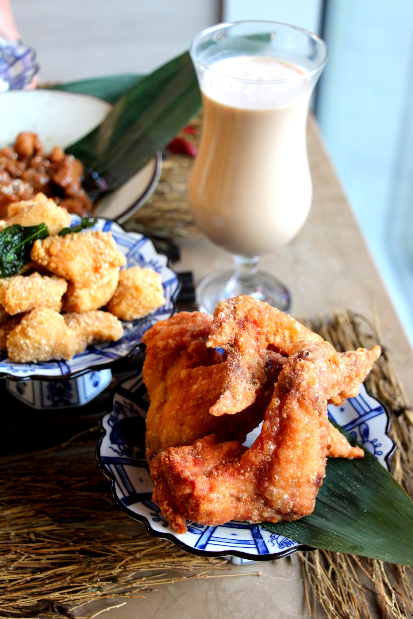 Milk tea beside a plate of Taiwanese fried chicken
