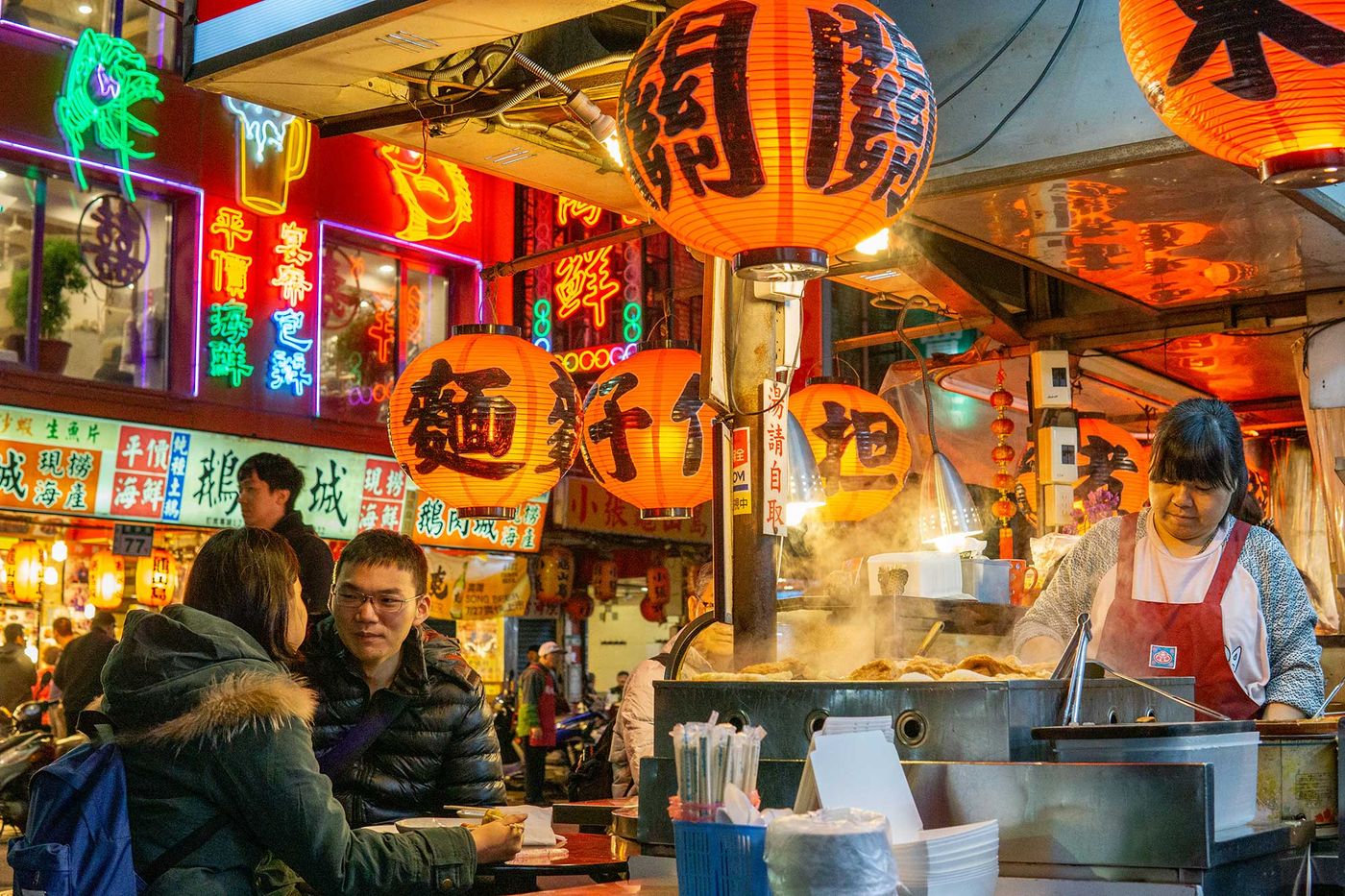 A busy Taiwanese night market stall under red lanterns
