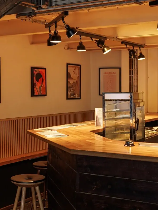 The Church Street dining room: a wooden counter, stools and warm pendant lights